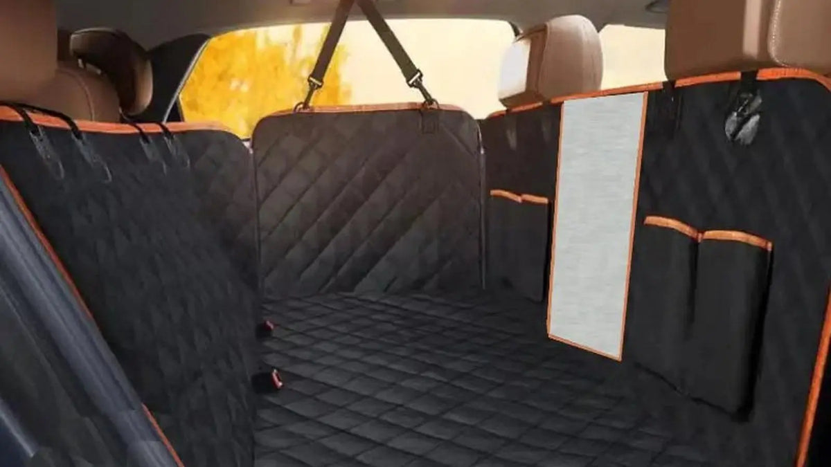 Housse de siège auto pour chien installée en hamac sur la banquette arrière d'un SUV, protection matelassée noire à liseré orange